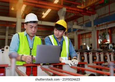 Asian Male Hard Hat Chief Engineer Uses Laptop To Train Workers To Check Checks Heavy Metal Machinery There Is A Team Working Behind The Scenes. Concepts, Factory Workers. Mechanical Engineering