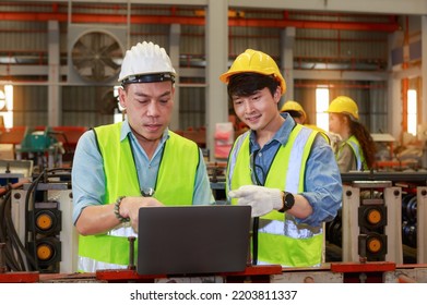 Asian Male Hard Hat Chief Engineer Uses Laptop To Train Workers To Check Checks Heavy Metal Machinery There Is A Team Working Behind The Scenes. Concepts, Factory Workers. Mechanical Engineering