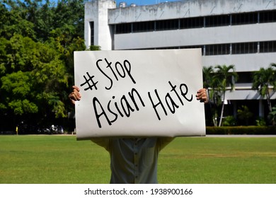 Asian male holds a paper sign with English words ‘#Stop Asian Hate’, concept for calling the international community to stop the hatred of the Asian people that have caused spreading of the covid-19.