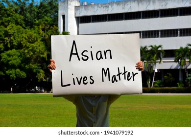 Asian male holds a paper sign with English words ‘Asian Lives Matter’, concept for calling the international community to stop the hatred of the Asian people that has caused spreading of the covid-19.