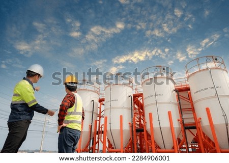 Asian male industrial engineer working Inspection and maintenance of factory water storage tanks or water systems in engineering plants.