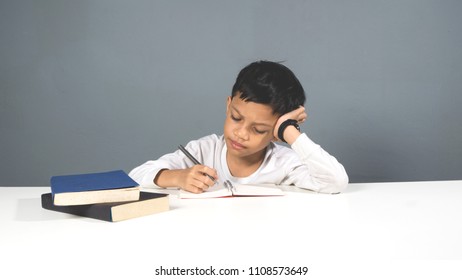 Asian male kid doing homework on his study table.  - Shutterstock ID 1108573649