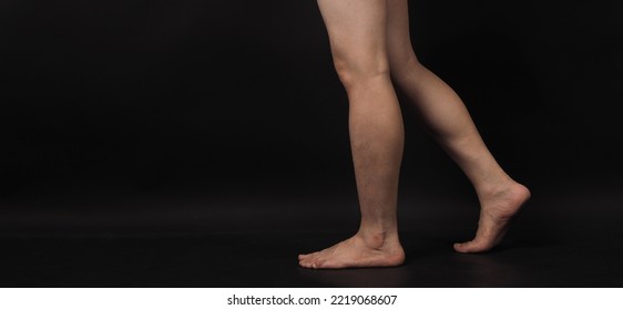 Asian Male Legs And Barefoot Is Isolated On Black Background.