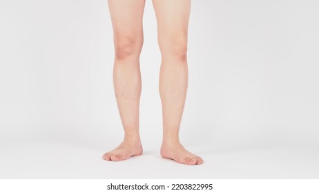 Asian Male Legs And Barefoot Is Standing On White Background.