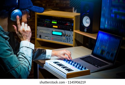 Asian Male Music Producer Composing A Song In Digital Sound Studio