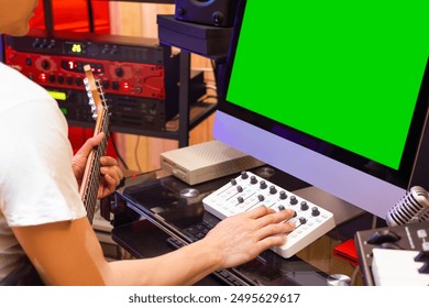 asian male musician recording electric guitar track on desktop computer in home studio - Powered by Shutterstock