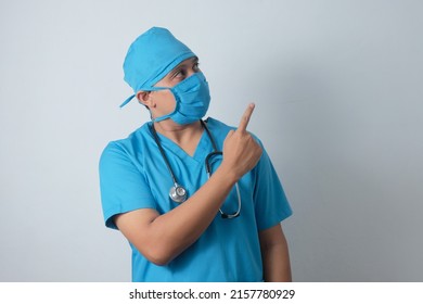 Asian Male Nurse Pointing Finger To The Top