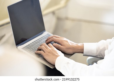 Asian Male Passenger In Airplane Use Computer Notebook Laptop And Wifi On Board, Young Asian Business Man Use Computer Laptop Traveling By Airplane Connecting Wifi.