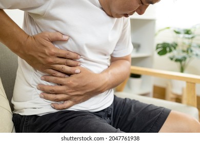 Asian Male Patient With Abdominal Pain On Right Side Belly,painful In Abdomen,irritable Bowel,middle-aged Man Holds Under The Ribs,stomach Ache,cirrhosis Of The Liver Disease,liver Cancer Concept