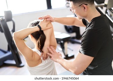 Asian male personal trainer to assist with stretching - Powered by Shutterstock