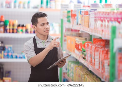 Asian Male Shopkeeper Working In A Grocery Store