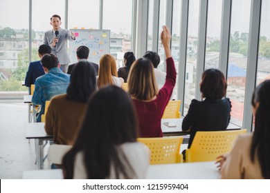 Asian male speaker is speaking at seminars and workshops to the people in the meeting. Participants are raising their hands to ask questions. - Powered by Shutterstock