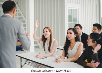 Asian male speaker is speaking at seminars and workshops to the people in the meeting. Participants are raising their hands to ask questions. - Powered by Shutterstock