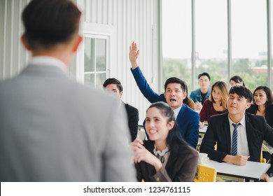 Asian male speaker is speaking at seminars and workshops to the people in the meeting. Participants are raising their hands to ask questions. - Powered by Shutterstock