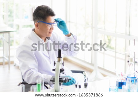 An Asian male Thai scientist is wearing glasses to prevent chemicals and germs in the biological laboratory in the morning. Conceptual Concept for Antiretroviral drugs Corona 2019 from Wuhan, China
