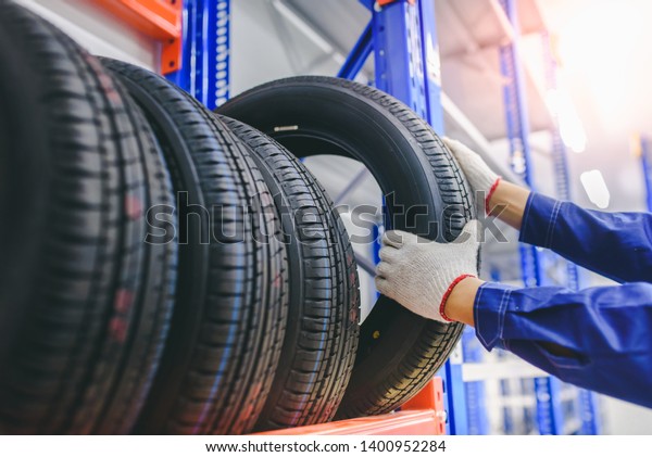 	\
Asian male tire changer In the process\
of checking the condition of new tires in stock so that they can be\
replaced at a service center or auto repair shop. Tire warehouse\
for the car\
industry	\
