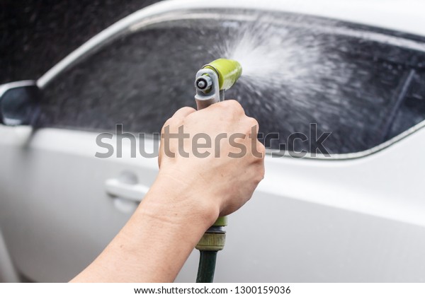 Asian male washing\
car in the garden - Image