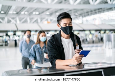 Asian Male Wearing Face Mask Traveler Giving Boarding Pass And Passport To Customer Check In Officer At Service Counter Airport.Man Wearing Face Mask When Traveling To Prevent Coronavirus Pandemic.