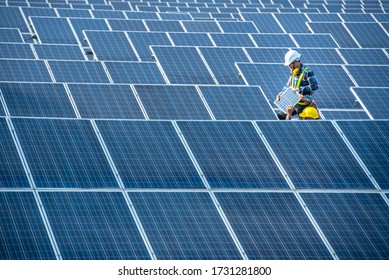 An Asian male worker is about to install solar panels. At the solar power generating station Asian workers take orders and install solar cells. - Shutterstock ID 1731281800