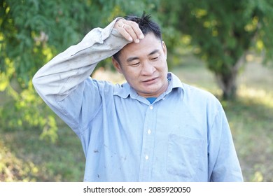 Asian Male Worker Feels Tired After Working In Garden. Concept : Feeling And Emotions. Farmer Work Hard Against Poverty. 