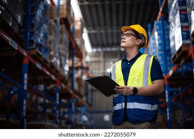 Asian male worker wearing Hard Hat with clipboard Checks Stock and Inventory in the Retail Warehouse.  - Powered by Shutterstock