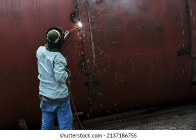 Asian Male Worker Is Welding A Large Steel Pipe.