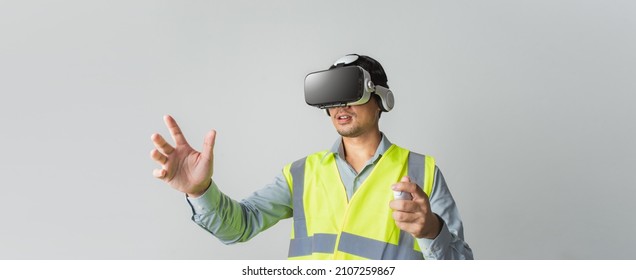Asian man Architect or Engineer designer using VR headset with joystick for design working in studio short on banner gray background.