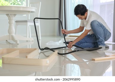 Asian Man Assembling Furniture At Home