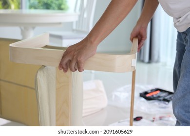 Asian Man Assembling Furniture At Home