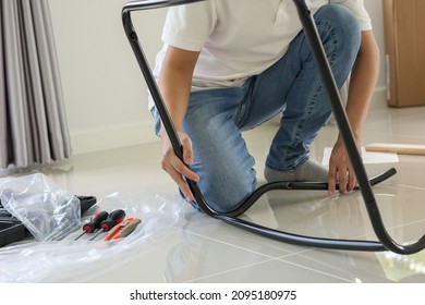 Asian Man Assembling Furniture At Home