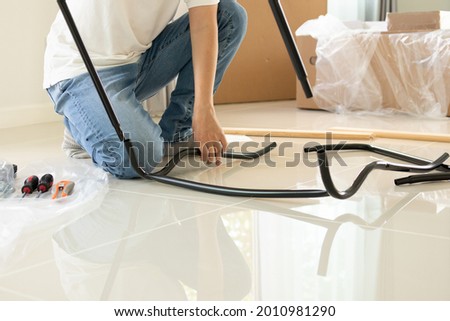 Asian man assembling furniture at home