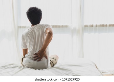 Asian Man Back Pain And Sit On Bed In Bedroom In The Morning.color Tone