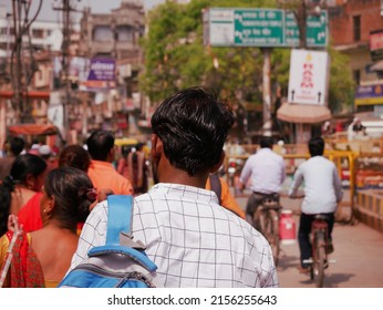 An asian man with bag on shoulder going with city crowd, people on the background at Varanasi Uttar Pradesh in India shot captured on March 2022.