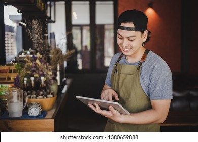 asian man barista holding tablet for checking order from customer on coffee cafe. - Shutterstock ID 1380659888