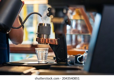 Asian Man Barista Making Hot Espresso Shot From Flair Espresso Coffee Maker At Cafe. Male Coffee Shop Owner Brewing Black Coffee Serving To Customer. Small Business Restaurant Food And Drink Concept