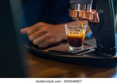 Asian Man Barista Making Hot Espresso Shot From Flair Espresso Coffee Maker At Cafe. Male Coffee Shop Owner Brewing Black Coffee Serving To Customer. Small Business Restaurant Food And Drink Concept