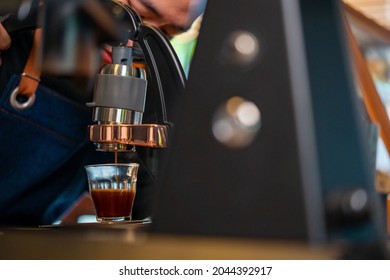 Asian Man Barista Making Hot Espresso Shot From Flair Espresso Coffee Maker At Cafe. Male Coffee Shop Owner Brewing Black Coffee Serving To Customer. Small Business Restaurant Food And Drink Concept