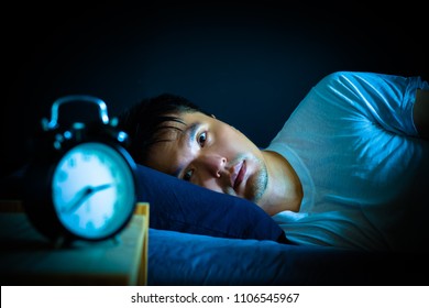 asian man in bed suffering insomnia and sleep disorder thinking about his problem at night - Shutterstock ID 1106545967