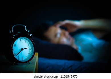 asian man in bed suffering insomnia and sleep disorder thinking about his problem at night - Shutterstock ID 1106545970