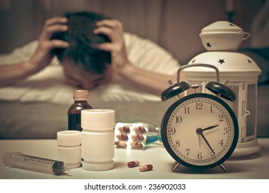 Asian Man In Bed With Tablets And Drugs Suffering Insomnia, Hangover, Headache At Night