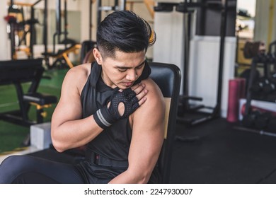 An asian man bothered by a bum shoulder. A possible mild or chronic rotator cuff injury at the gym.