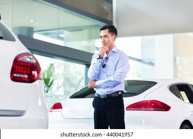 Asian Man Buying Luxury Car In Dealership