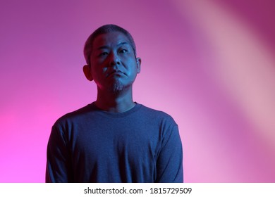 The Asian Man With Buzz Haircut Is Shot With Studio Gel Lighting.