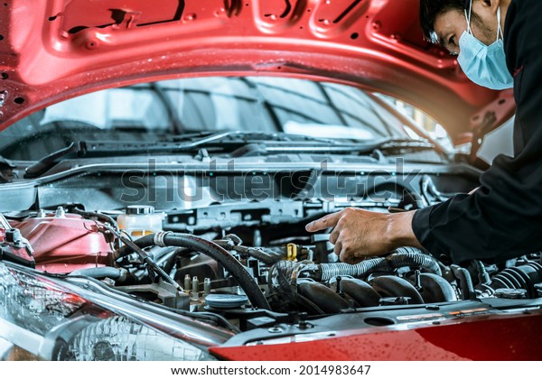 Asian man car inspection holding taplet\
application for service car for car futuristic vehicle graphical\
GUI interface intelligent. connected car. Internet display\
technician maintenance