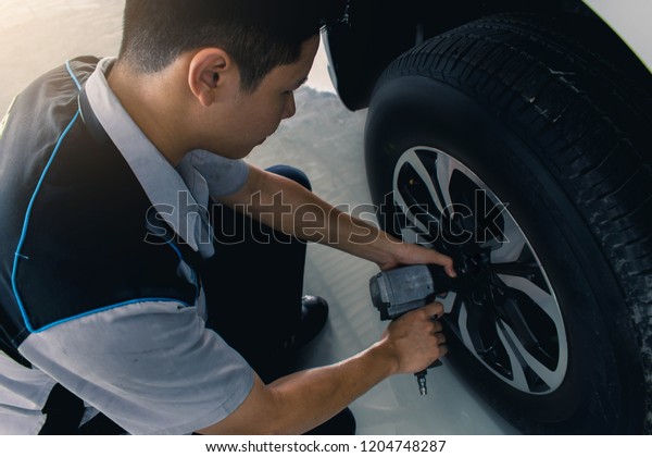 Asian man car inspection Measure quantity Inflated\
Rubber tires\
car.Close up hand holding machine Inflated pressure\
gauge for car tyre\
pressure measurement for automotive, automobile\
image