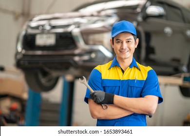 Asian Man In Car Service, Repair, Maintenance And People Concept, Happy Smiling Auto Mechanic Man Or Smith With Clipboard At Workshop