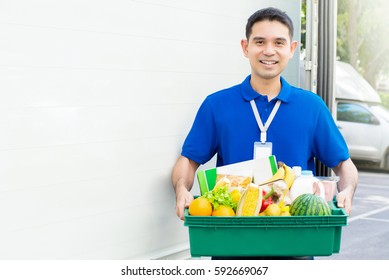 Asian Man Carrying Food Basket Beside The Car - Grocery Delivery Service Concept