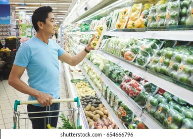 Asian Man Choosing Paper In Supermarket