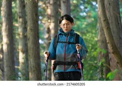 Asian Man Climbing A Mountain