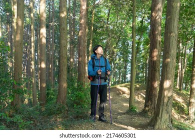 Asian Man Climbing A Mountain